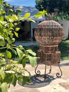 a bird cage sitting on the ground in a yard at Villa Pauline in Avignon