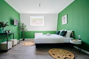 - une chambre avec des murs verts et un grand lit dans l'établissement NG SuiteHome - Lille I Roubaix Jouffroy - Netflix - Wifi, à Roubaix