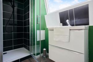 La salle de bains est pourvue d'une douche et d'une douche vitrée. dans l'établissement NG SuiteHome - Lille I Roubaix Jouffroy - Netflix - Wifi, à Roubaix