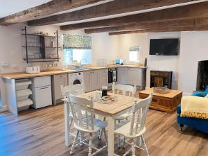 a kitchen and dining room with a table and chairs at The Cottage at Sychnant Farm in Talgarth