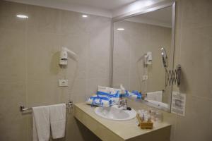 a bathroom with a sink and a mirror at Residencial La Quinta Park Suites in Santa Úrsula