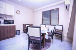 a dining room with a table and chairs and a clock at Tbilisi Tower Apartment in Tbilisi City