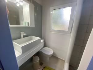 baño con lavabo y aseo y ventana en Two Bedroom 2 Bathroom House, en Fanari