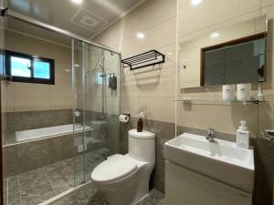 La salle de bains est pourvue de toilettes, d'un lavabo et d'une douche. dans l'établissement 月月寓室 Luna INN 民宿, à Yilan City