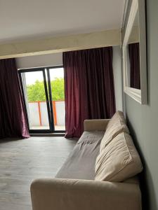 um sofá num quarto com uma grande janela em vivo residence ,AMETHYST em Floresti