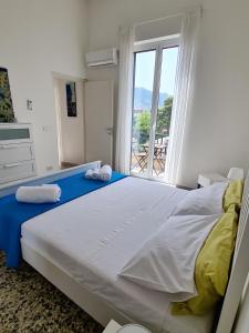 a bedroom with a large bed with a large window at Àrima Mondello Apartment in Mondello