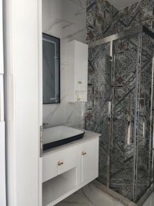 a bathroom with a shower and a sink at Imperador Palace Hotel Restorant in Peshkopi