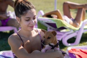 a young woman holding a small dog at the beach at Residenza Principina in Principina Terra