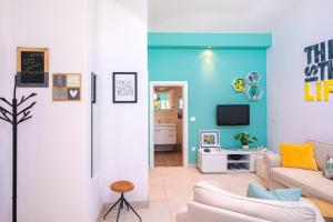 uma sala de estar com um sofá e uma televisão em Tamburika colorful apartment in rustica area em Krk