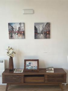 a wooden table in front of a white wall with pictures at Ensuite Private Room in Central Stylish Flat in Leicester
