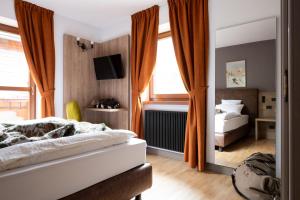 - une chambre avec un lit et un grand miroir dans l'établissement Chalet Vedig, à Santa Caterina di Valfurva