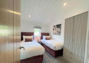 a bedroom with two beds and a sliding door at Bowland Escapes in Chipping