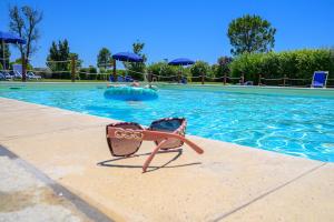 a pool with a beach chair sitting next to a swimming pool at Residenza Principina in Principina Terra