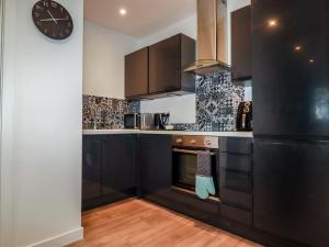 a kitchen with black cabinets and a clock on the wall at Pheasant View in Truro