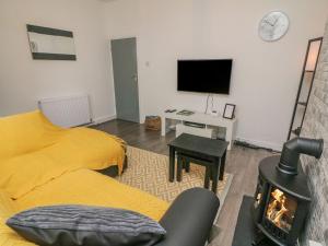 a living room with a fireplace and a tv at 2 Brook Street in Clitheroe