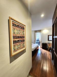 a room with a bed and a painting on the wall at The Peaberry Boutique Hotel in Chiang Mai