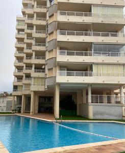 an apartment building with a swimming pool in front of it at Upscale, fully renovated apartment next to the beach with direct sea view in Calpe