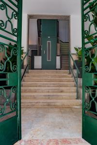 an open door leading up to a staircase with green doors at Succeed Campo Pequeno Suites in Lisbon