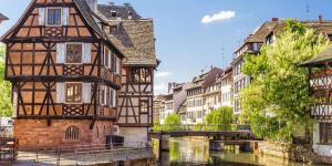 an old building next to a river in a city at Cozy Studio Strasbourg in Strasbourg