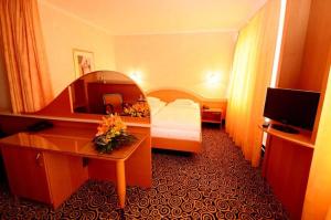 Pokój hotelowy z sypialnią z łóżkiem i biurkiem w obiekcie Hotel Eroplán w mieście Rožnov pod Radhoštěm