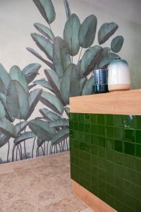 a bathroom with a plant mural on the wall at Succeed Campo Pequeno Suites in Lisbon