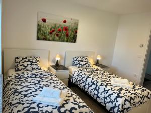 a bedroom with two beds and a painting on the wall at Villa Kovačeva 15, app 1, free parking in Ljubljana