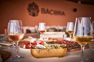 uma mesa com copos de vinho e um prato de comida em Universal Grand León & Spa em Colonia Sant Jordi