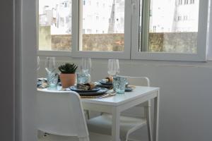 a white table with glasses and a plate of food at Succeed Campo Pequeno Suites in Lisbon