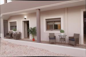 a patio with chairs and tables on a house at Niriides Apartments in Porto Heli