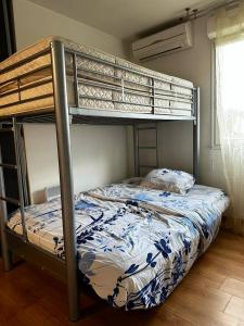 sypialnia z łóżkiem piętrowym z niebiesko-białą narzutą w obiekcie Maison de 3 chambres avec jacuzzi jardin clos et wifi a Fretoy le Chateau 