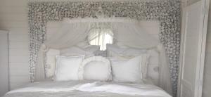 a white bed with white pillows and a window at Sušarna Romantik in Pouzdřany