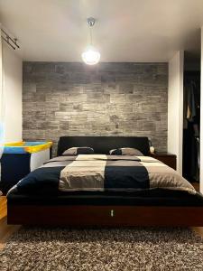 ein Schlafzimmer mit einem großen Bett mit Ziegelwand in der Unterkunft Maison de 3 chambres avec jacuzzi jardin clos et wifi a Fretoy le Chateau 