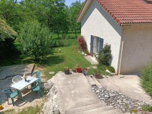 a small backyard with a table and chairs and a patio at La maison dans les noyer in Sainte-Eulalie