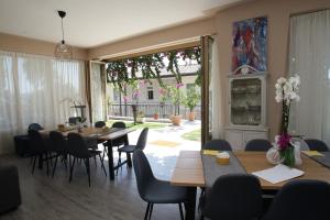 une salle à manger avec des tables et des chaises ainsi qu'une grande fenêtre dans l'établissement Villa Ai Colli, à Salò