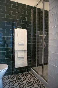 a bathroom with a glass shower with towels at Succeed Campo Pequeno Suites in Lisbon