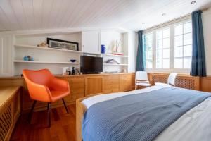 - une chambre avec un lit, une télévision et une chaise dans l'établissement Casa Margaux by PortofinoHomes, à Portofino