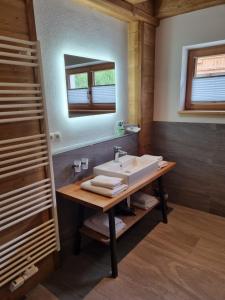 a bathroom with a sink and a mirror at Schickster Mountain Lodge in Unterweidach