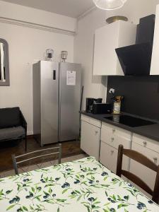 Marseille Vieux Port في مارسيليا: مطبخ مع ثلاجة ستانلس ستيل وطاولة +5 صور