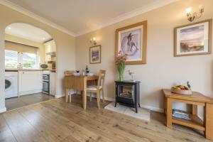 a living room with a table and a stove at Little Emmaus in Cley next the Sea