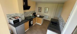 a small kitchen with a stove and a microwave at Les Chails Gite in Les Forges