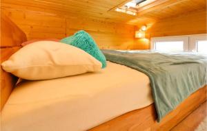 Una cama en una cabaña de madera con almohadas. en Cozy Home In Mayrhof With House A Panoramic View 