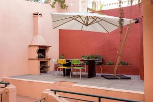 um pátio com uma mesa, cadeiras e um guarda-sol em JOIVY Exquisite apt with patio in Graça em Lisboa