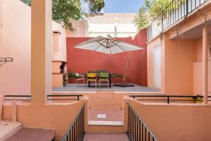 um pátio com uma mesa e um guarda-chuva em JOIVY Exquisite apt with patio in Graça em Lisboa