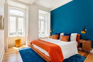 um quarto com uma parede azul e uma cama grande em JOIVY Exquisite apt with patio in Graça em Lisboa
