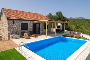 a swimming pool in front of a house at Villa Ivanka in Neum
