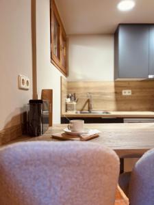 una cocina con una mesa de madera con una taza. en Casa Moline Apartamentos Rurales en Aneto