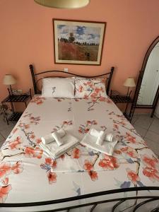 un letto con copriletto floreale e asciugamani di Depy's house a Nea Makri