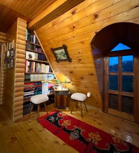 um quarto com duas cadeiras, uma mesa e uma estante de livros em Household Jakic em Pljevlja
