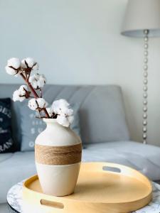 een witte vaas met bloemen op een tafel bij Cozy studio, easy access to Helsinki and near shopping center in Helsinki