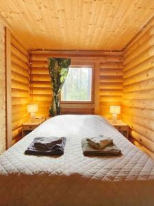 1 dormitorio con 1 cama con 2 albornoces. en Unique winter holiday in pine forest, en Forssa